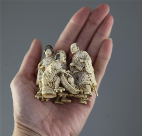 A good Japanese ivory okimono of five street pedlars or performers, signed Ikkosai, Meiji period, height 6.2cm